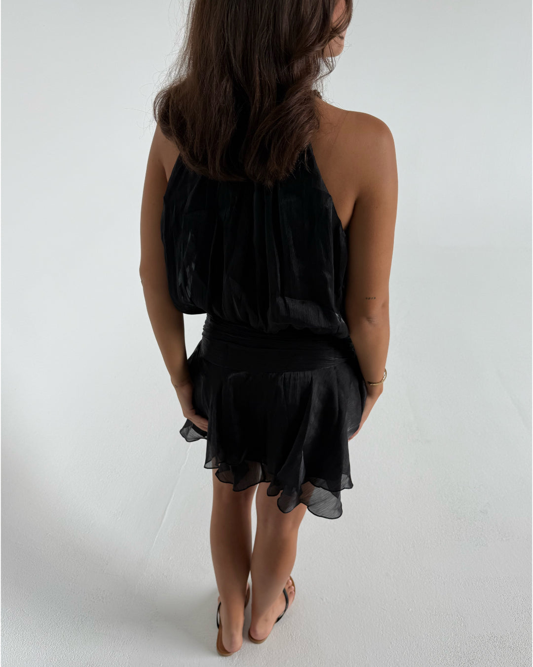 Modelfoto af pige som bærer en sort Vera kjole, samt Carmen sandaler. Hvid baggrund. Alt fra By Sofie Sønderby
