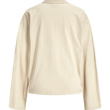 Beige, langærmet T-shirt set bagfra; løs pasform med rund halsudskæring. Enkel, ensfarvet design uden mønster, fotograferet på en ensfarvet baggrund.
