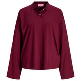 En mørkerød langærmet poloshirt hænger mod en hvid baggrund. Skjorten har en krave og tre knapper. Mærket viser "BRYX" i pink tekst.