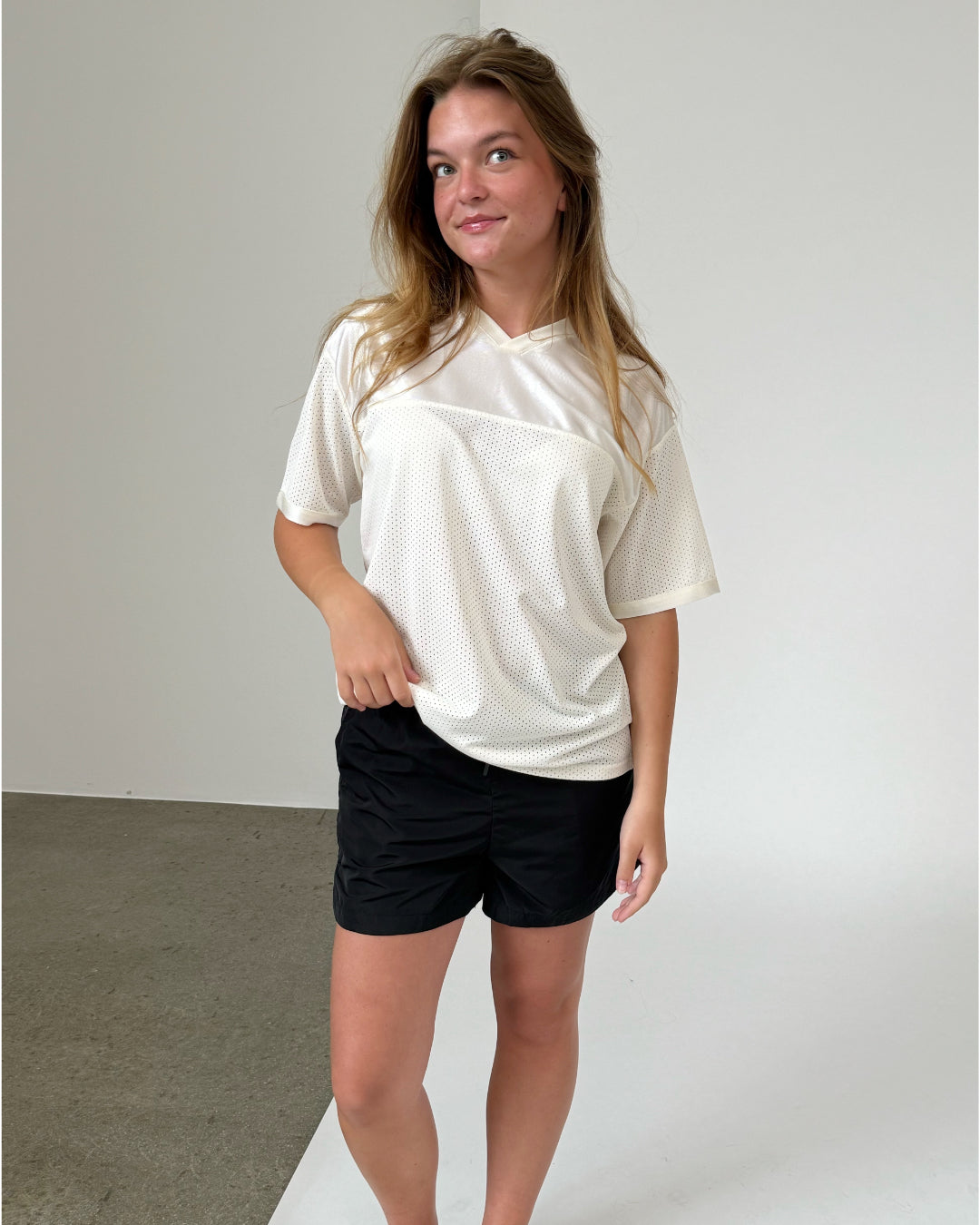 Modelfoto af pige iklædt ZOLA t-shirt, hvid og LANA shorts, sort - begge fra BySofieSønderby