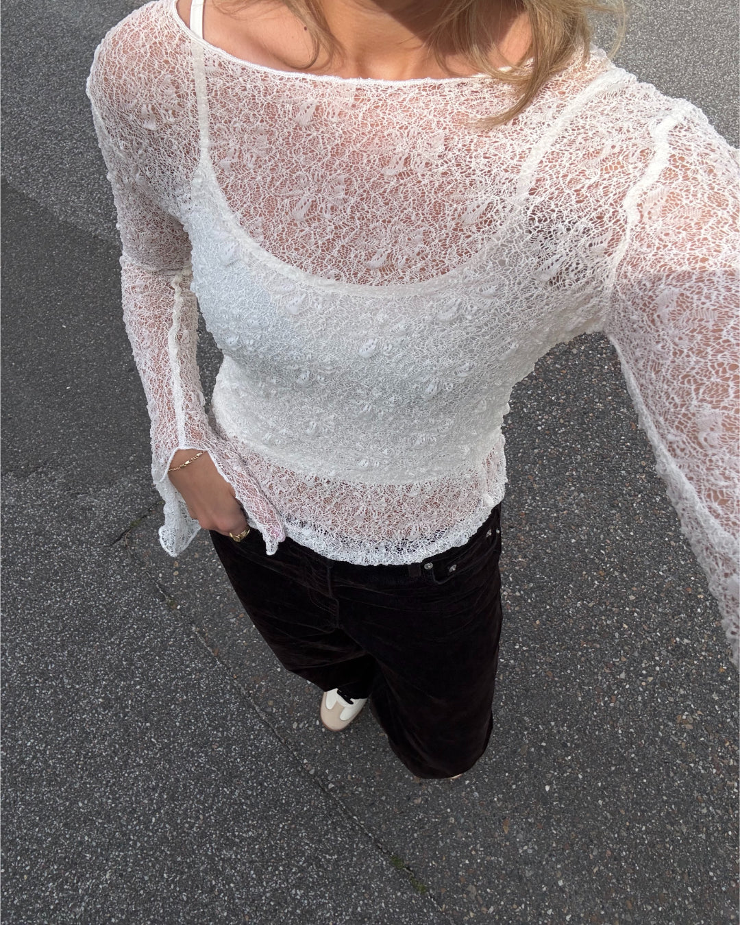 Modelfoto af pige i hvid Zoya blondebluse og sorte jeans. Alt er fra BySofieSønderby