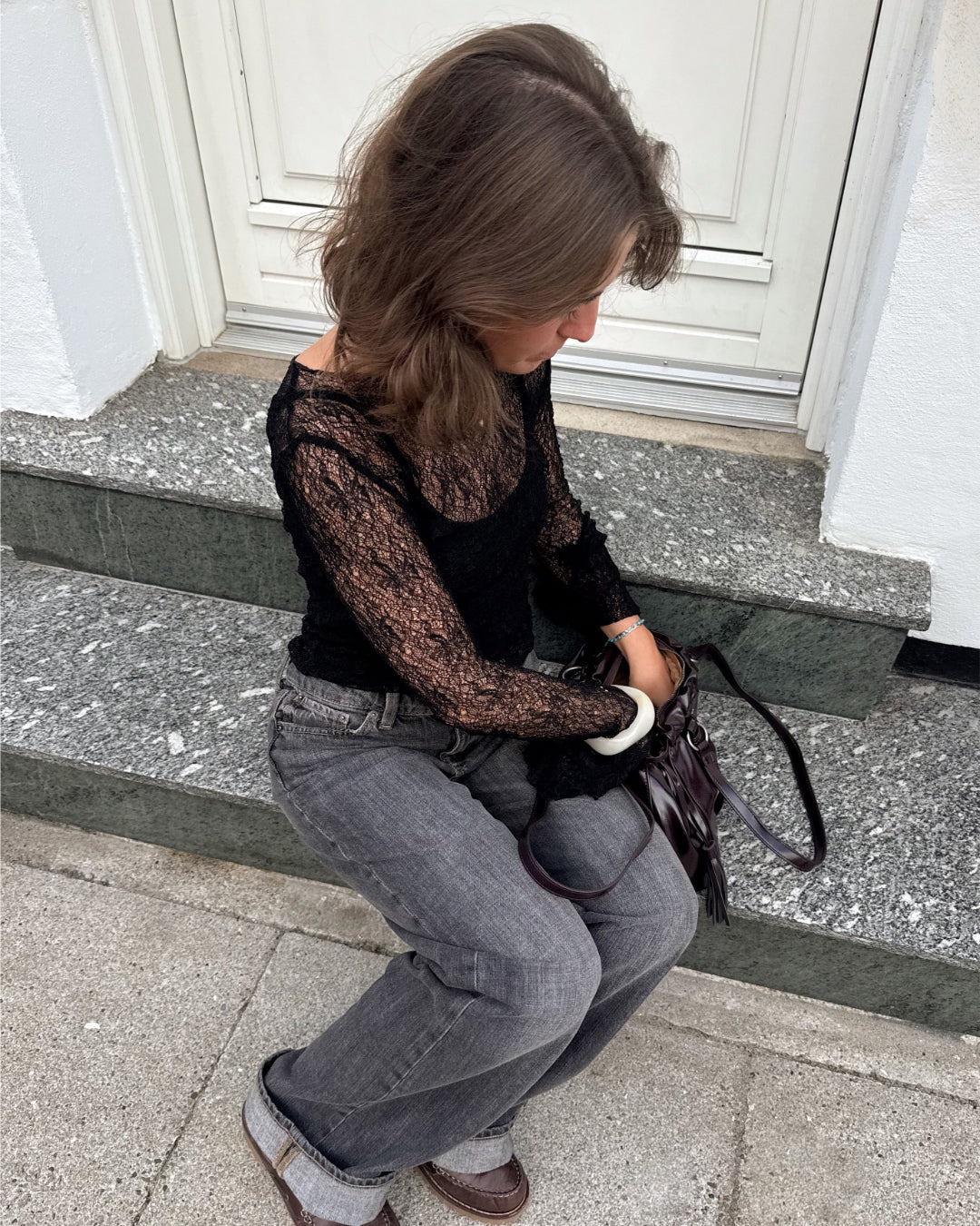Modelfoto af pige i sort Zoya blondebluse og grå Nanna jeans. Alt er fra BySofieSønderby