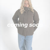 Modelfoto af pige i brun Global jakke. Teksten "coming soon" står henover billedet. Fra BySofieSønderby
