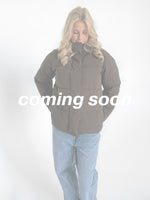 Modelfoto af pige i brun Global jakke. Teksten "coming soon" står henover billedet. Fra BySofieSønderby