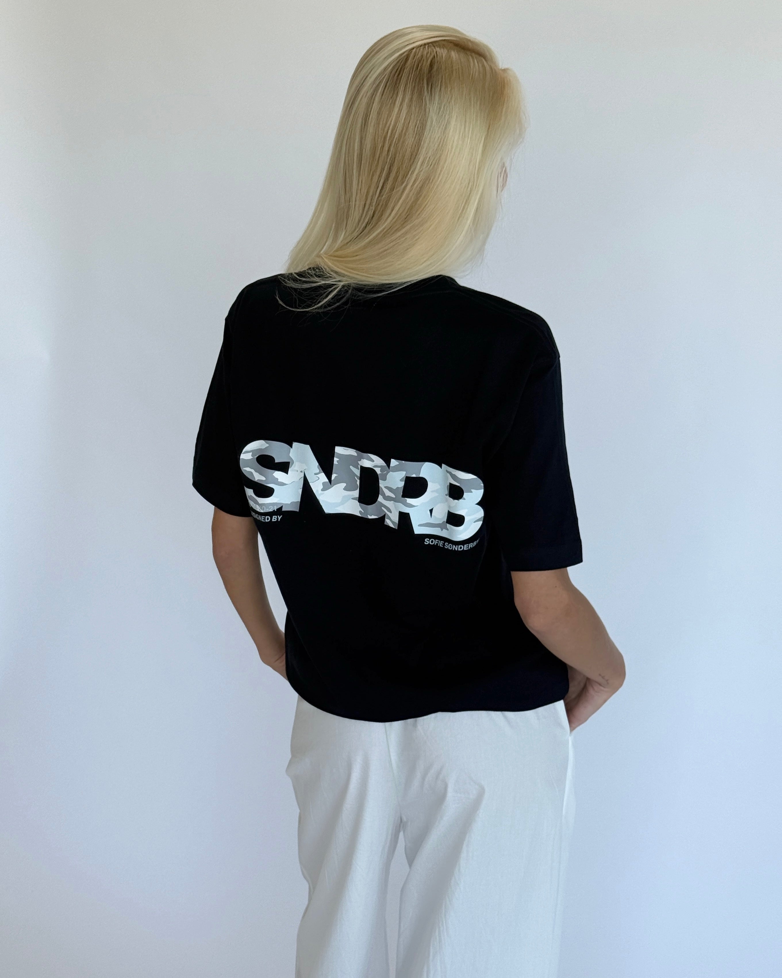 Modelbillede af navy SNDRB t-shirt med grå camouflage tryk. Set bagfra. Fra BySofieSønderby