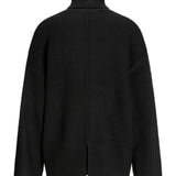 En sort sweater med høj hals præsenteres; den har et løst fit og en slids midt bagpå, fremhævet mod en hvid baggrund.