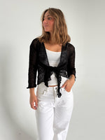 Modelfoto af pige som bærer en Arabella bluse i sort, samt et par hvide jeans. Alt fra By Sofie Sønderby