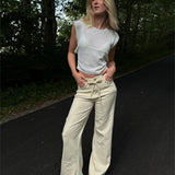 Modelfoto af pige i cremefarvede Arianna jeans og hvid Taytum top. Alt er fra BySofieSønderby