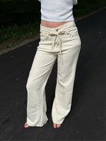 Modelfoto af pige i cremefarvede Arianna jeans og hvid top. Alt er fra BySofieSønderby