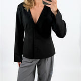 Modelfoto af pige med sort ARIA blazer, samt grå MILAN bukser. Set forfra. Alt er fra BySofieSønderby