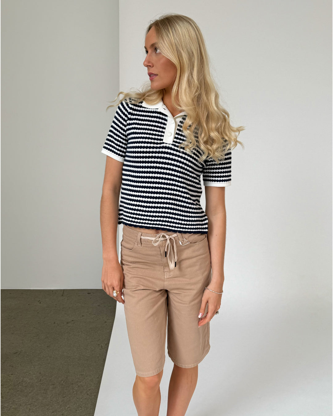 Modelfoto af pige iklædt ASHLEY polo, navy og AVERY jorts, sand - begge fra BySofieSønderby
