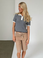 Modelfoto af pige iklædt ASHLEY polo, navy og AVERY jorts, sand - begge fra BySofieSønderby