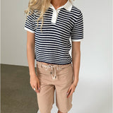 Modelfoto af pige iklædt ASHLEY polo, navy og AVERY jorts, sand - begge fra BySofieSønderby