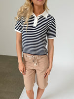 Modelfoto af pige iklædt ASHLEY polo, navy og AVERY jorts, sand - begge fra BySofieSønderby