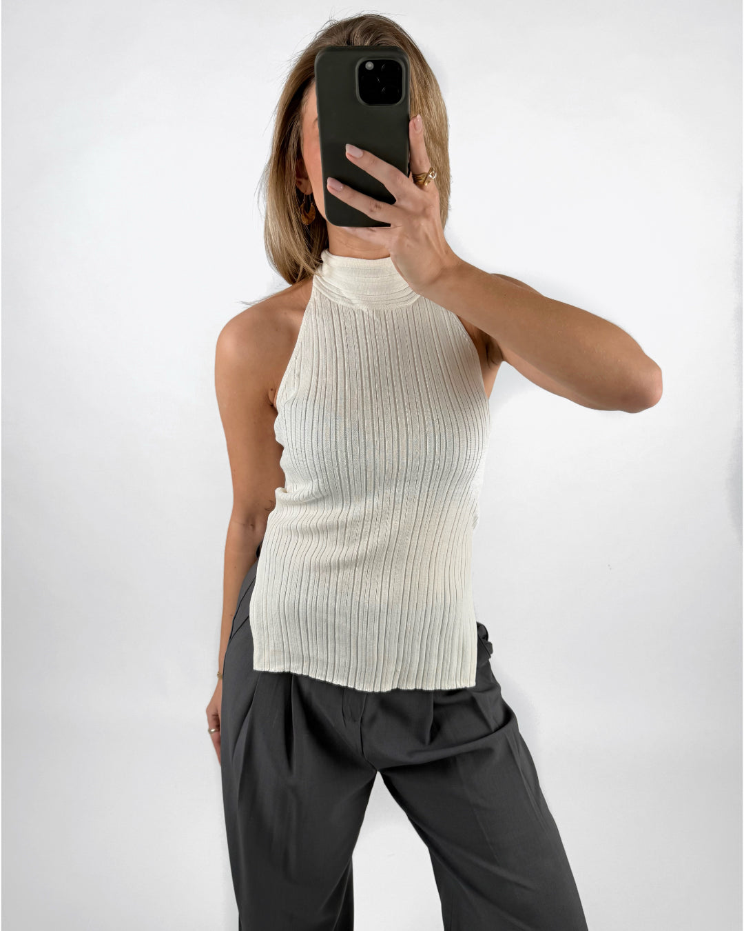 Modelfoto af pige med cremefarvet ASHLYN halterneck top, samt grå MILAN bukser. Set forfra. Alt er fra BySofieSønderby