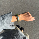 Modelfoto af en Avani guld armbånd. Baggrund er grå. Fra BySofieSønderby