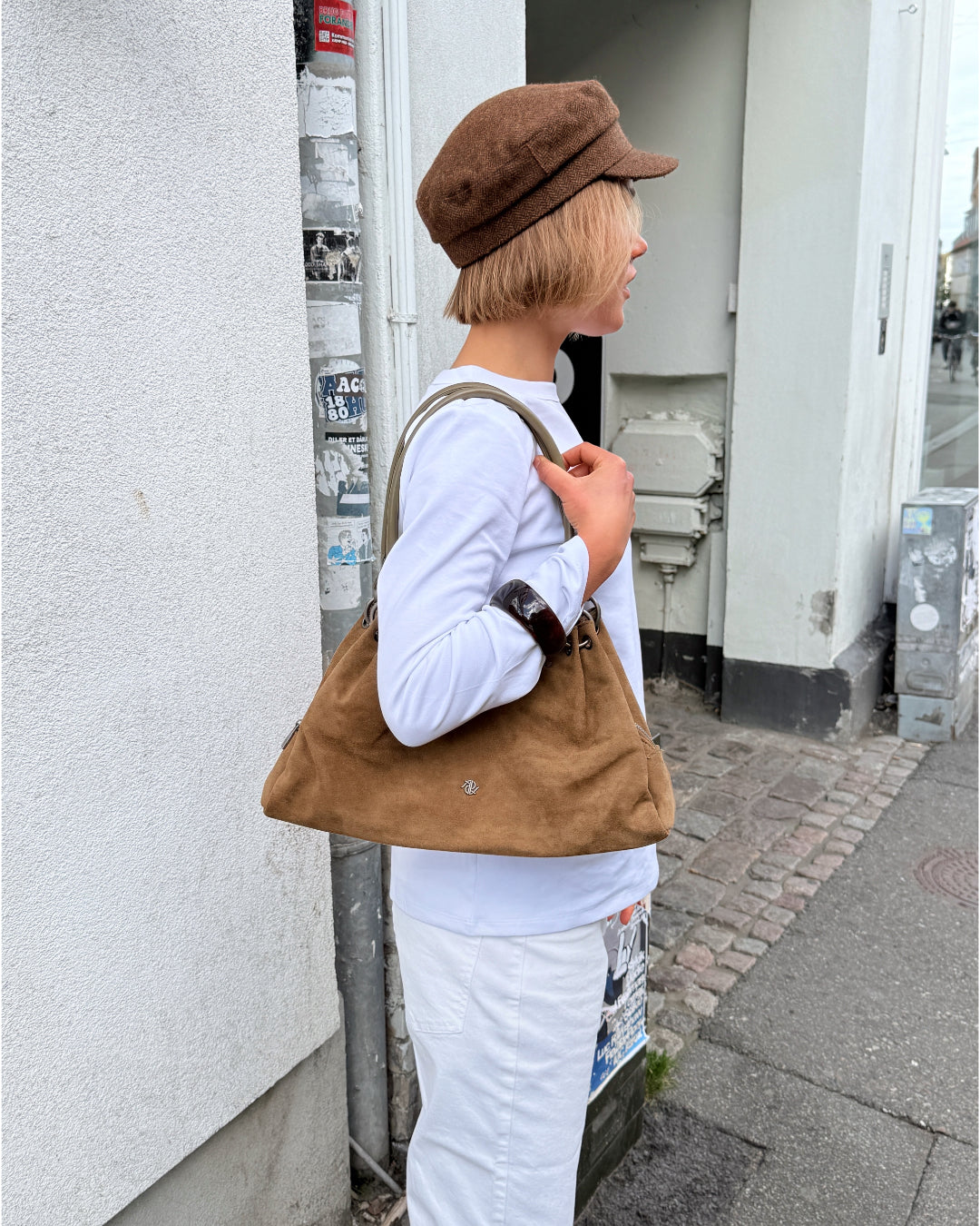 Modelbillede af pige der bærer brun AYLANI taske på skulderen. Fra BySofieSønderby.