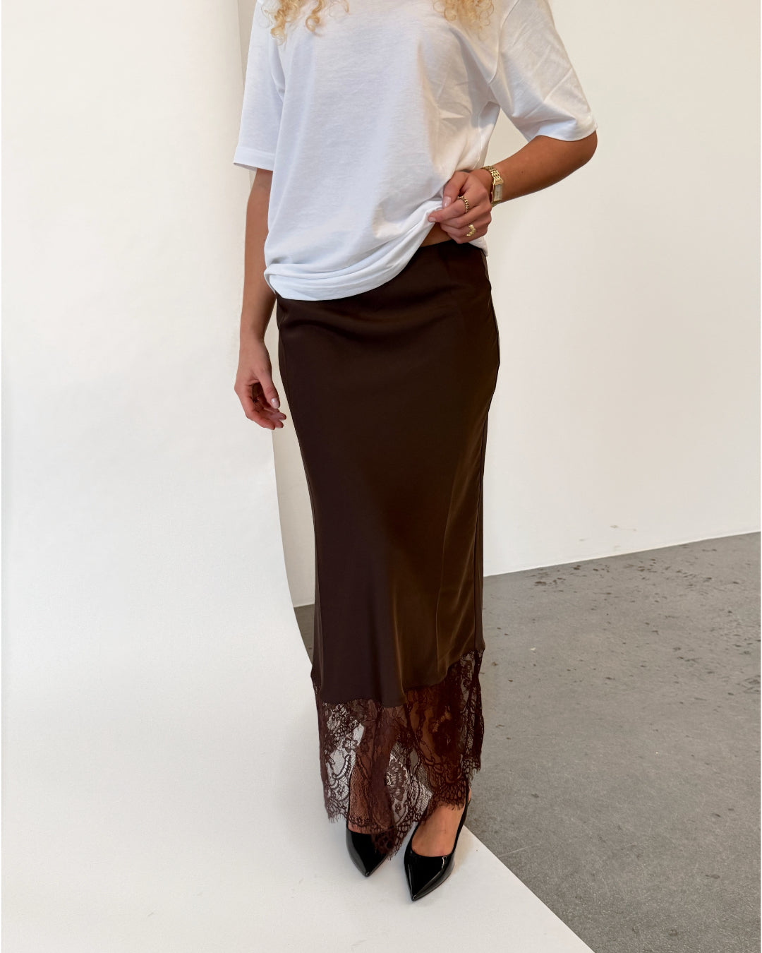 Modelfoto af pige i brun BILLIE nederdel, samt hvid t-shirt. Alt er fra BySofieSønderby.