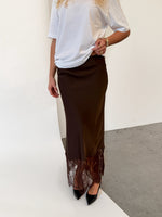 Modelfoto af pige i brun BILLIE nederdel, samt hvid t-shirt. Alt er fra BySofieSønderby.