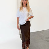 Modelfoto af pige i brun BILLIE nederdel, samt hvid t-shirt. Alt er fra BySofieSønderby.