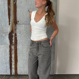 Modelfoto af pige der bærer Blakely top i hvid, samt grå Nanna jeans. Alt fra BySofieSønderby