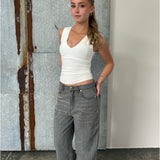 Modelfoto af pige der bærer Blakely top i hvid, samt grå Nanna jeans. Alt fra BySofieSønderby