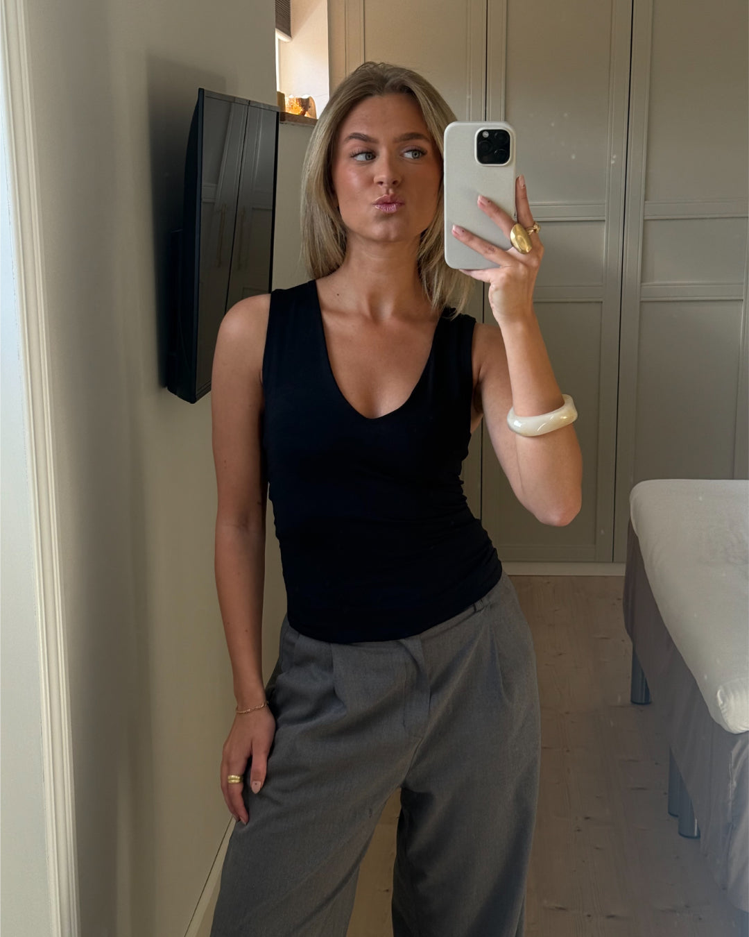 Modelfoto af pige der bærer Blakely top i sort, samt grå Lisa bukser. Alt fra BySofieSønderby