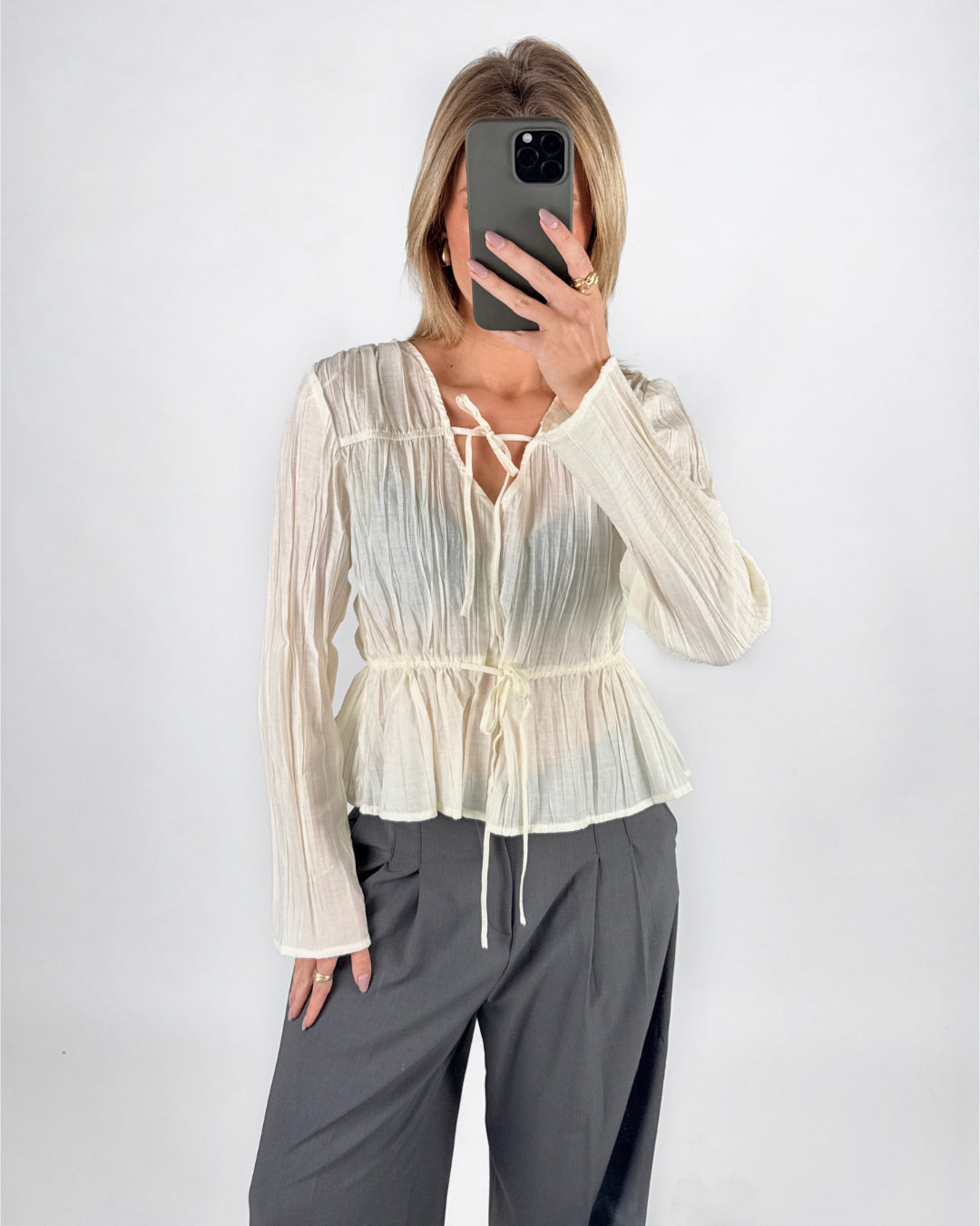 Modelfoto af pige i cremefarvet BREA bluse og grå LISA bukser. Alt er fra BySofieSønderby.