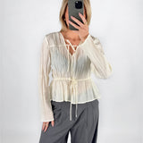 Modelfoto af pige i cremefarvet BREA bluse og grå LISA bukser. Alt er fra BySofieSønderby.