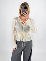 Modelfoto af pige i cremefarvet BREA bluse og grå LISA bukser. Alt er fra BySofieSønderby.