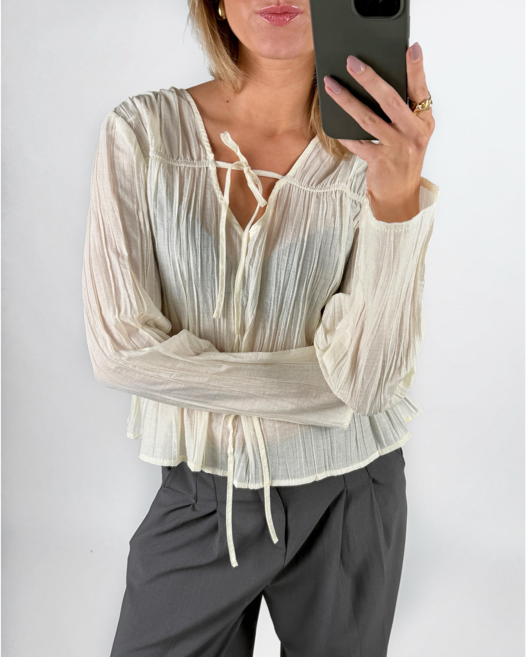 Modelfoto af pige i cremefarvet BREA bluse og grå LISA bukser. Alt er fra BySofieSønderby.