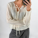 Modelfoto af pige i cremefarvet BREA bluse og grå LISA bukser. Alt er fra BySofieSønderby.