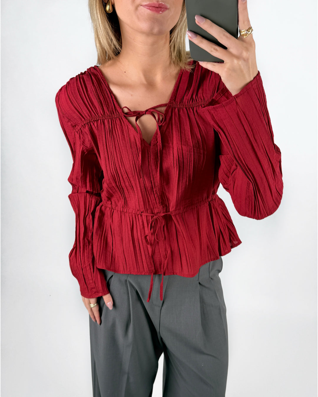 Modelfoto af pige i rød BREA bluse og grå LISA bukser. Alt er fra BySofieSønderby.