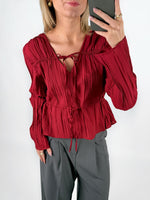 Modelfoto af pige i rød BREA bluse og grå LISA bukser. Alt er fra BySofieSønderby.