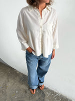 Modelfoto af pige som bærer en Breeze skjorte i hvid, samt et par blå Nanna jeans. Alt fra By Sofie Sønderby