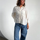 Modelfoto af pige som bærer en Breeze skjorte i hvid, samt et par blå Nanna jeans. Alt fra By Sofie Sønderby