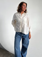 Modelfoto af pige som bærer en Breeze skjorte i hvid, samt et par blå Nanna jeans. Alt fra By Sofie Sønderby