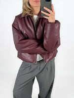 Modelfoto af pige i bordeaux CALA bomber jakke, og grå LISA bukser. Alt er fra BySofieSønderby.