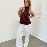 Modelfoto af pige i bordeaux CHILLI top, samt hvide NANNA jeans. Alt er fra BySofieSønderby.