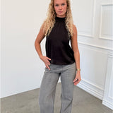 Modelfoto af pige i sort CHILLI top, samt grå NANNA jeans. Alt er fra BySofieSønderby.