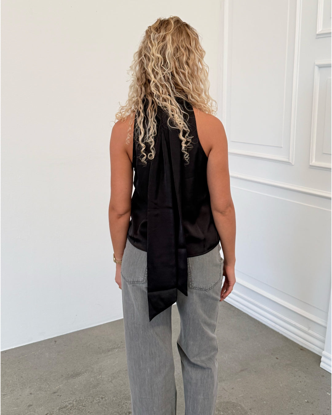 Modelfoto af pige i sort CHILLI top, samt grå NANNA jeans. Alt er fra BySofieSønderby.