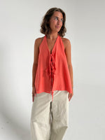 Modelfoto af pige som bærer en Daisy top i coral, samt et par beige Yale bukser. Alt fra By Sofie Sønderby