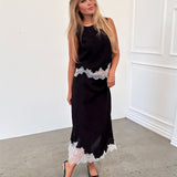 Modelfoto af pige i sort DALME nederdel med hvide blonder, samt matchende DALME top. Alt er fra BySofieSønderby.