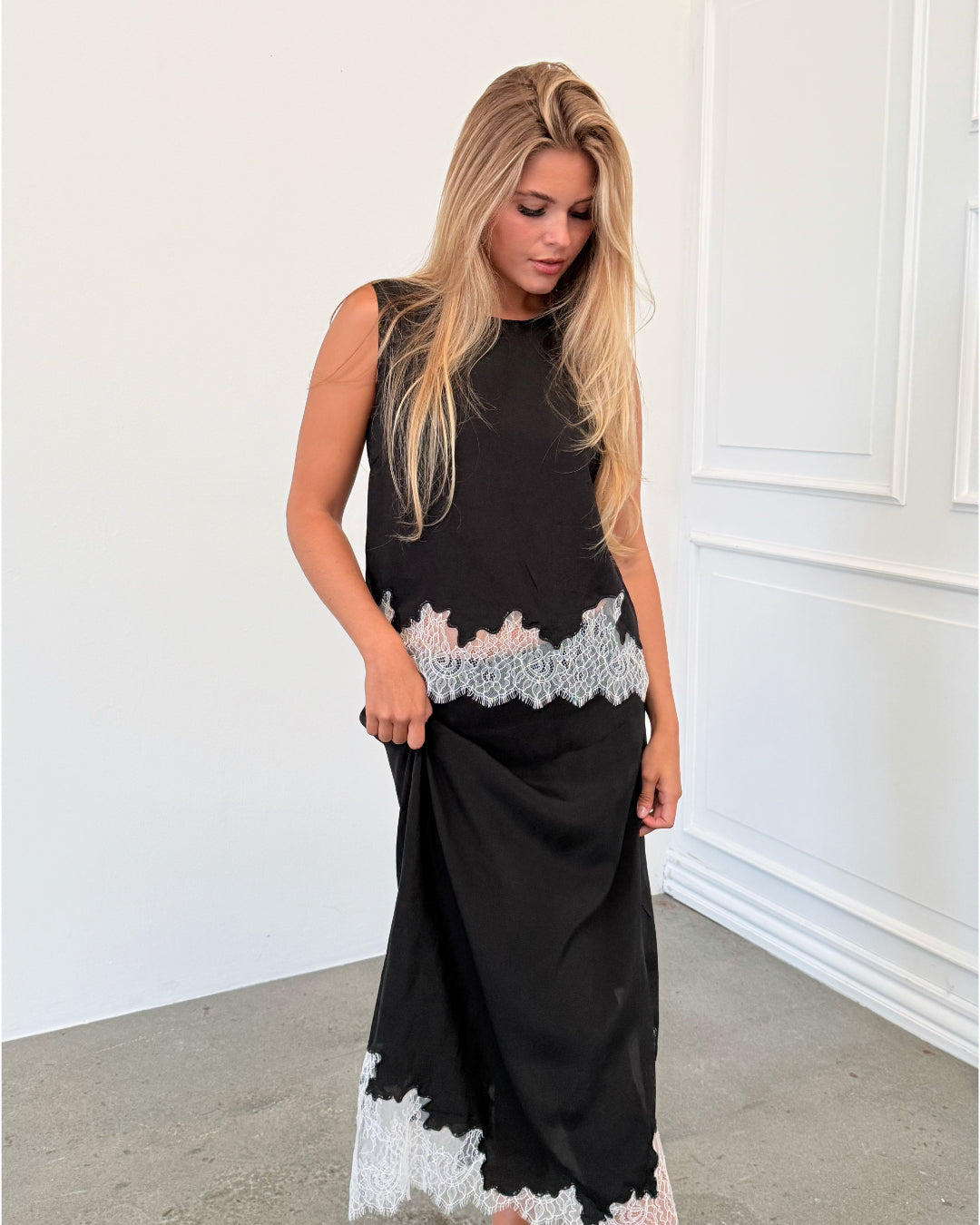 Modelfoto af pige i sort DALME top med hvide blonder, samt matchende DALME nederdel. Alt er fra BySofieSønderby.