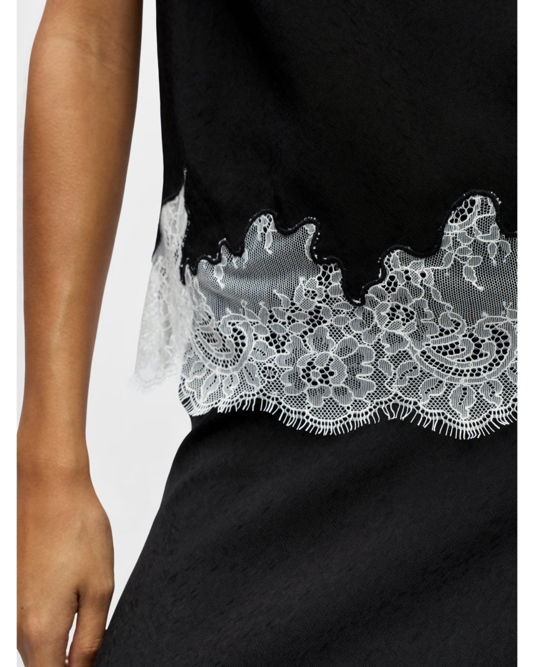 Detaljebillede af sort DALME top med hvide blonder. Fra BySofieSønderby