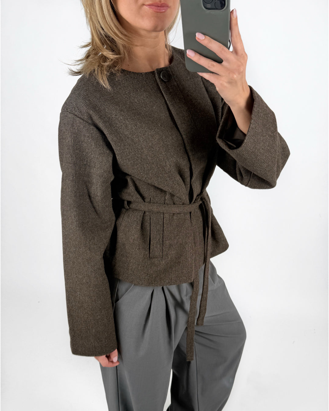 Modelfoto af pige i brun DARLA jakke med bindebånd, samt grå LISA bukser. Alt er fra BySofieSønderby.