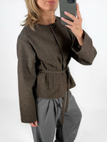 Modelfoto af pige i brun DARLA jakke med bindebånd, samt grå LISA bukser. Alt er fra BySofieSønderby.