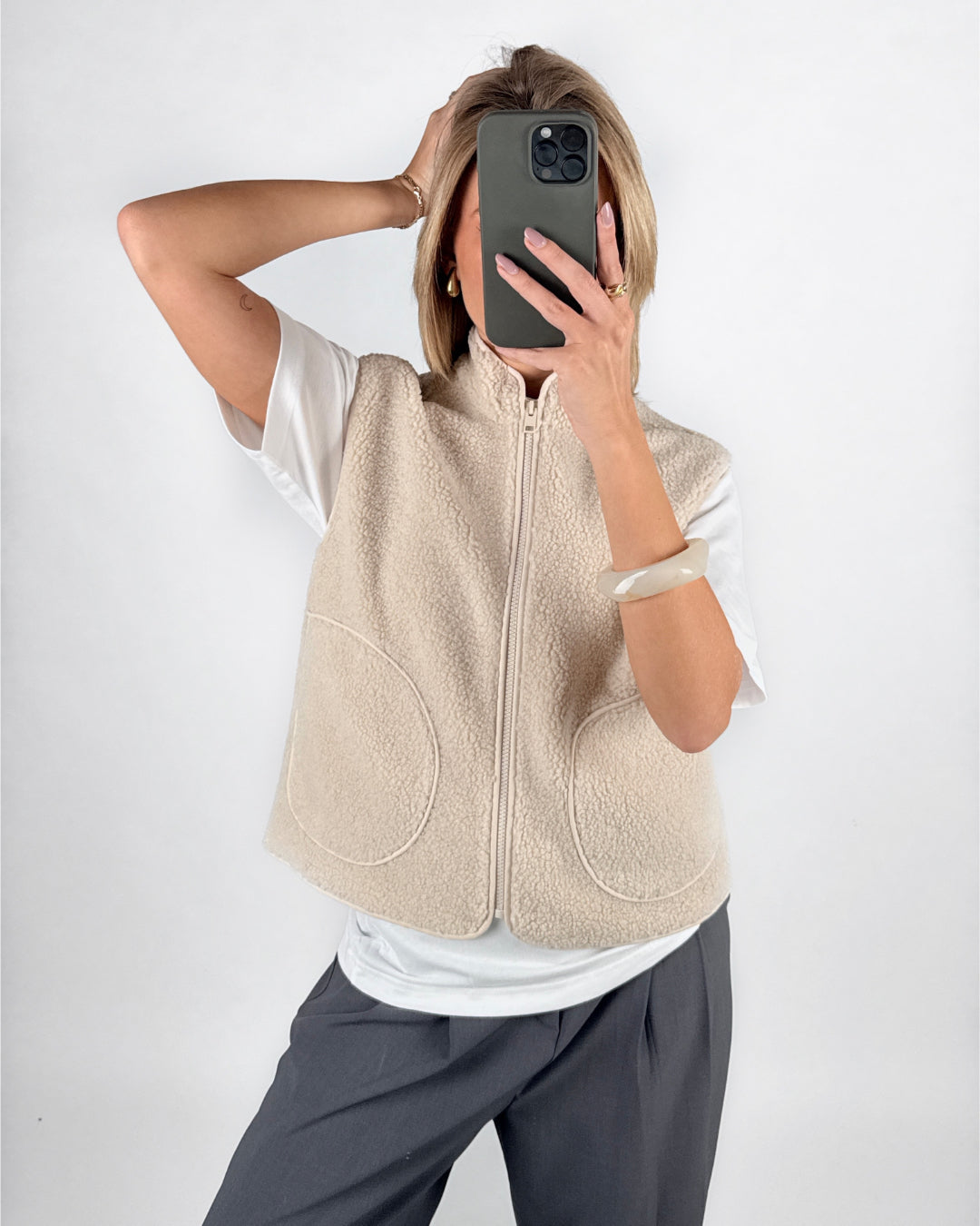 Modelfoto af pige i beige DAWN vest, hvid t-shirt og grå LISA bukser. Alt er fra BySofieSønderby.