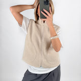 Modelfoto af pige i beige DAWN vest, hvid t-shirt og grå LISA bukser. Alt er fra BySofieSønderby.