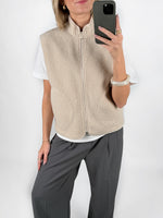 Modelfoto af pige i beige DAWN vest, hvid t-shirt og grå LISA bukser. Alt er fra BySofieSønderby.